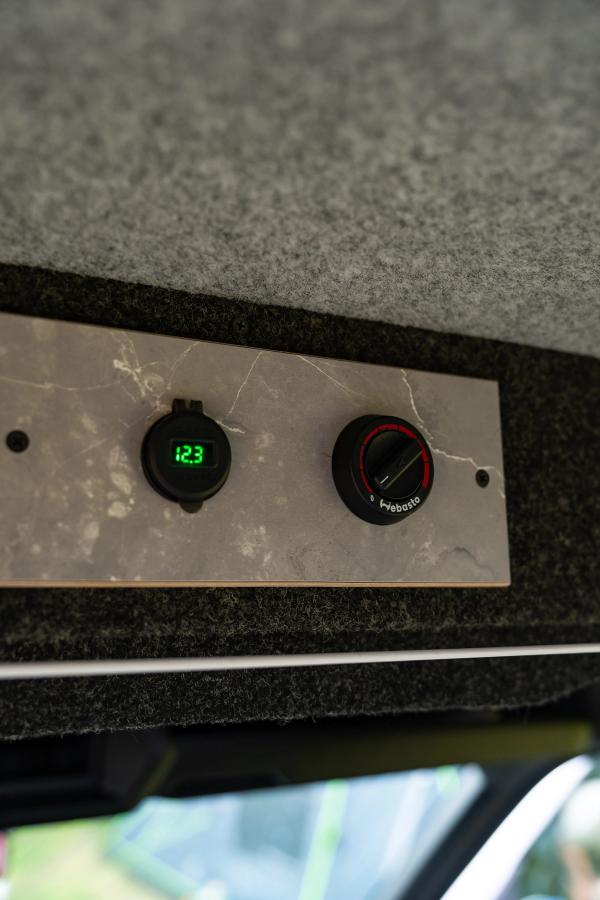 Voltage display and heater control dial on a panel inside a 5 person large camper