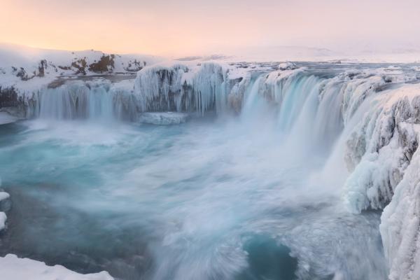 a partially frozen powerful waterfall during winter