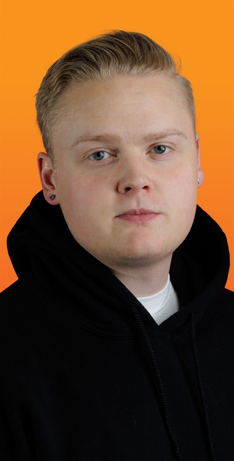 un homme blond porte un sweat noir à capuche 