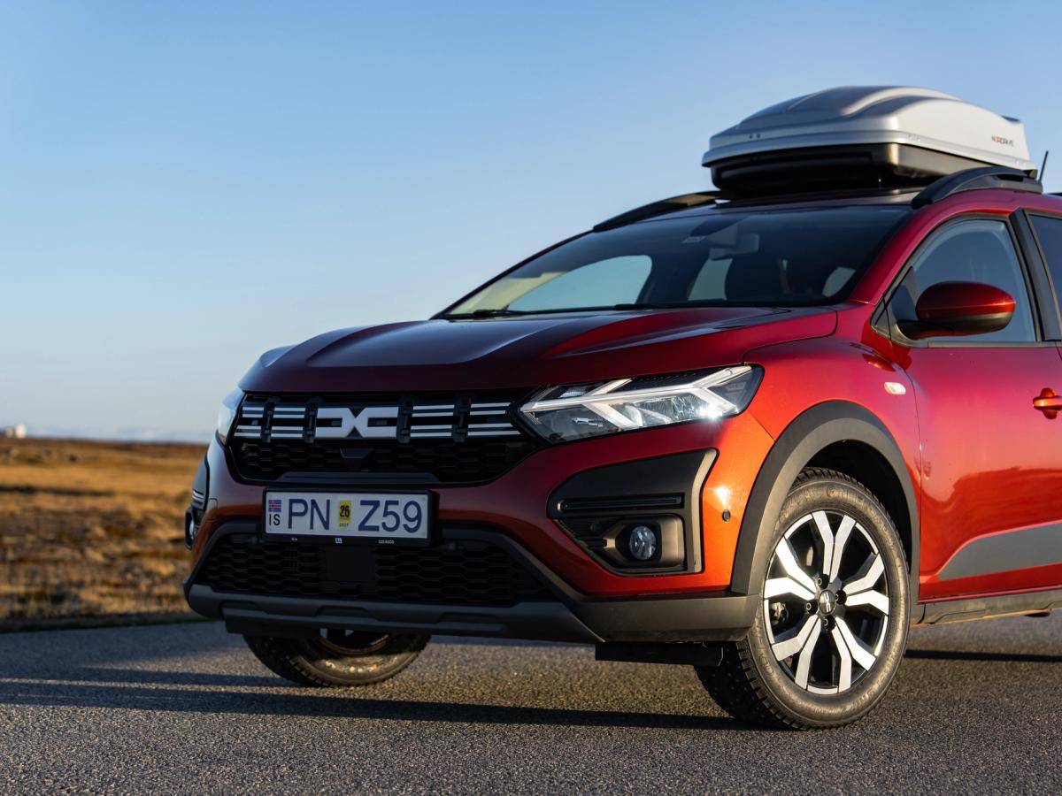 Cofre de techo delantero para Dacia Jogger Vista frontal en tres cuartos de un Dacia Jogger con cofre de techo, aparcado en una carretera asfaltada durante la hora dorada