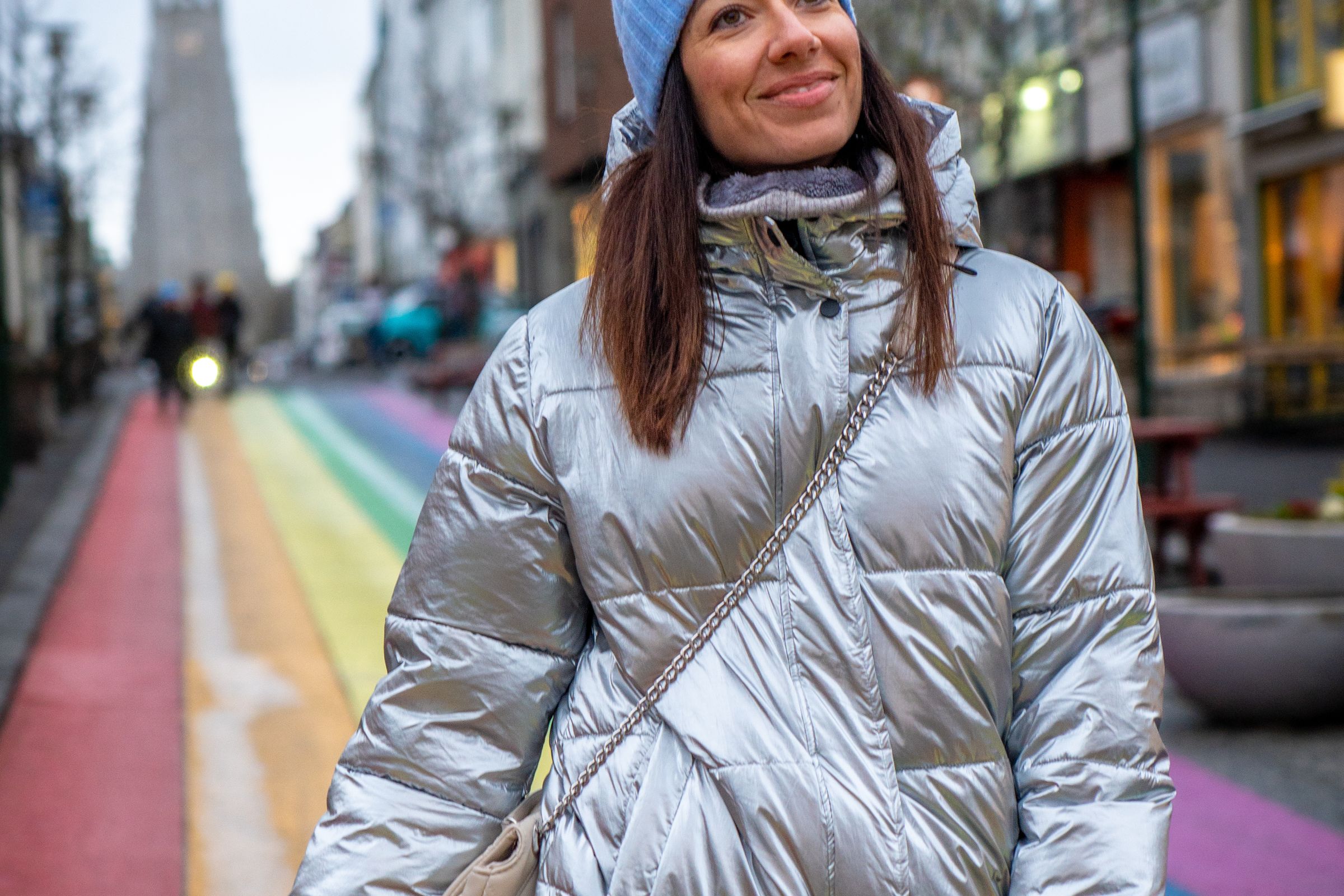 a woman wearing a silver jacket and a blue hat