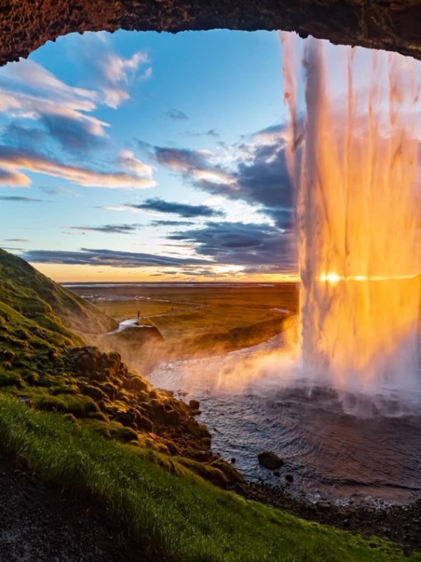 Midnight Sun in Iceland  sunset behind a beautiful waterfall in iceland