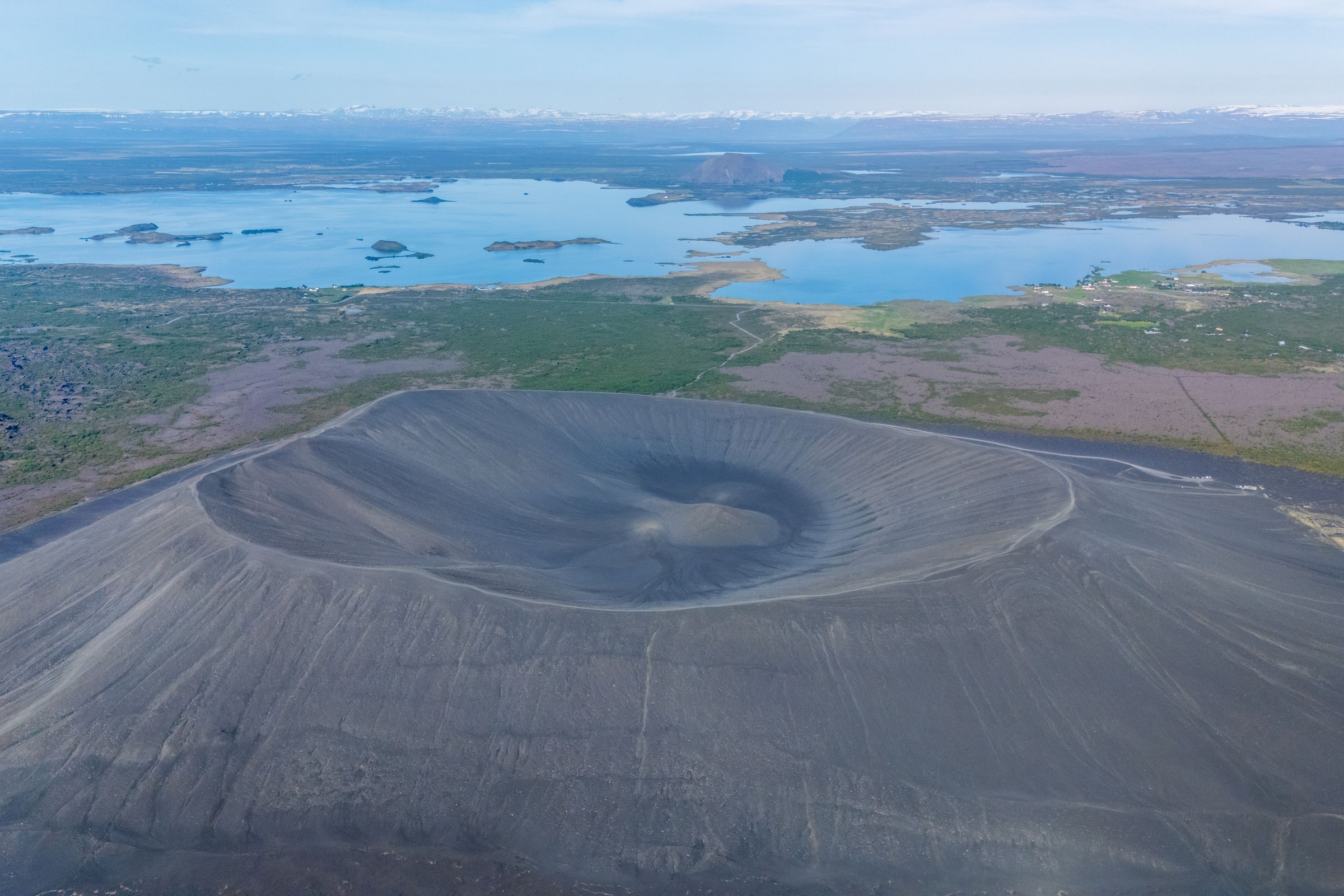 una vista aérea de un volcán con un lago en el fondo.