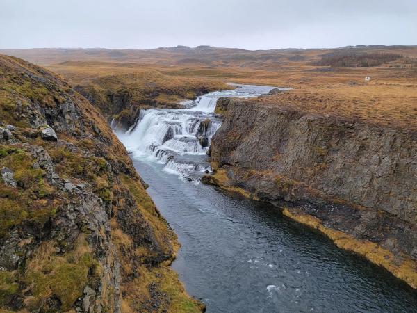 Fosslaug waterfall in the distance