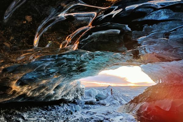 view of the sunset from the inside of an ice cave