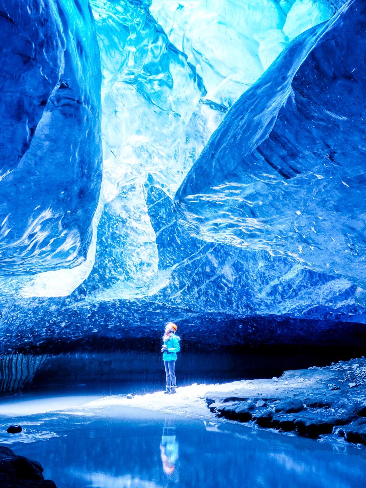 Chica en el medio de una cueva de hielo en Islandia
