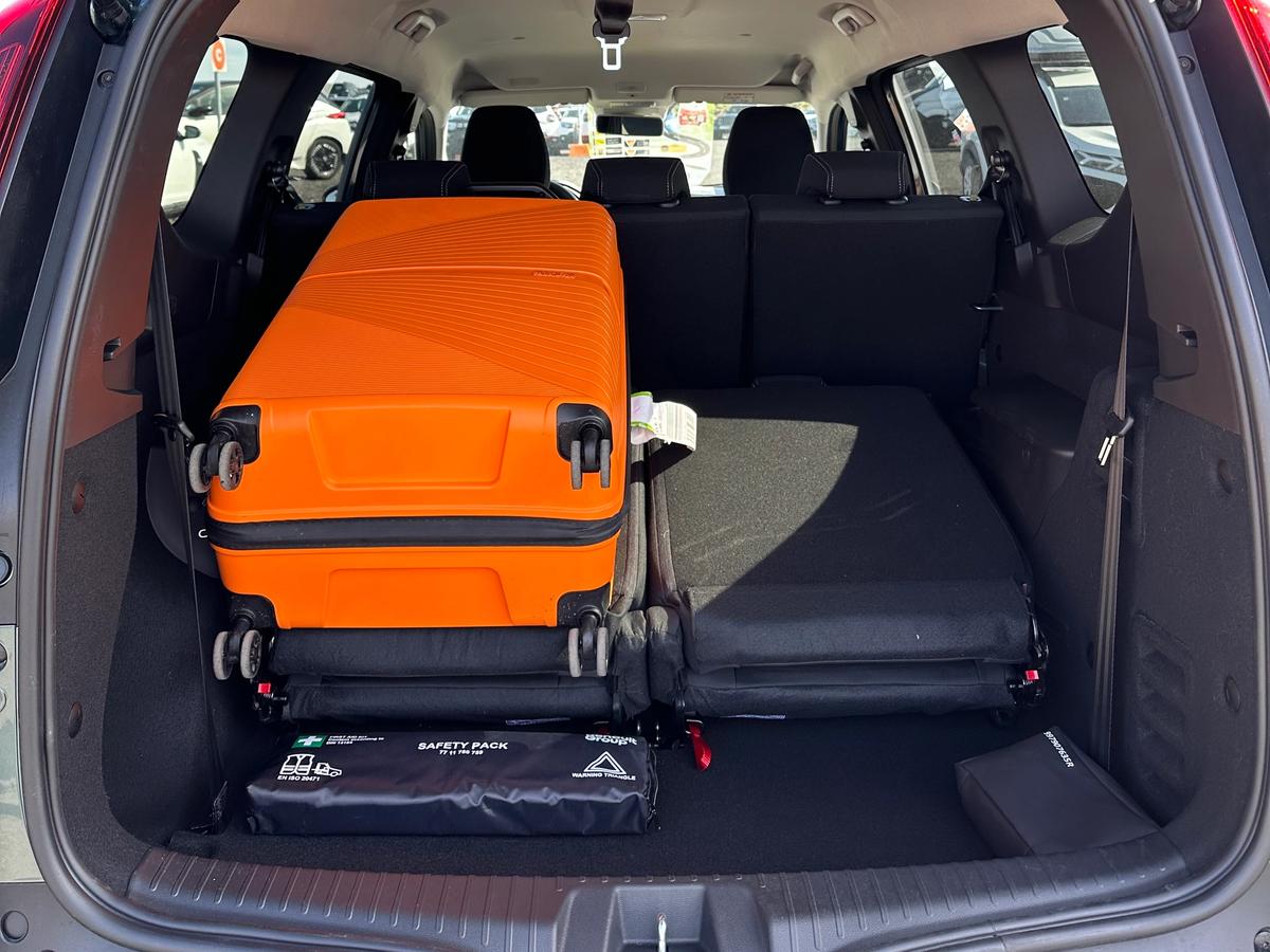 Kofferraumvolumen des Jogger Kofferraum des Dacia Jogger mit orangefarbenem Koffer zur Veranschaulichung des verfügbaren Gepäckraums