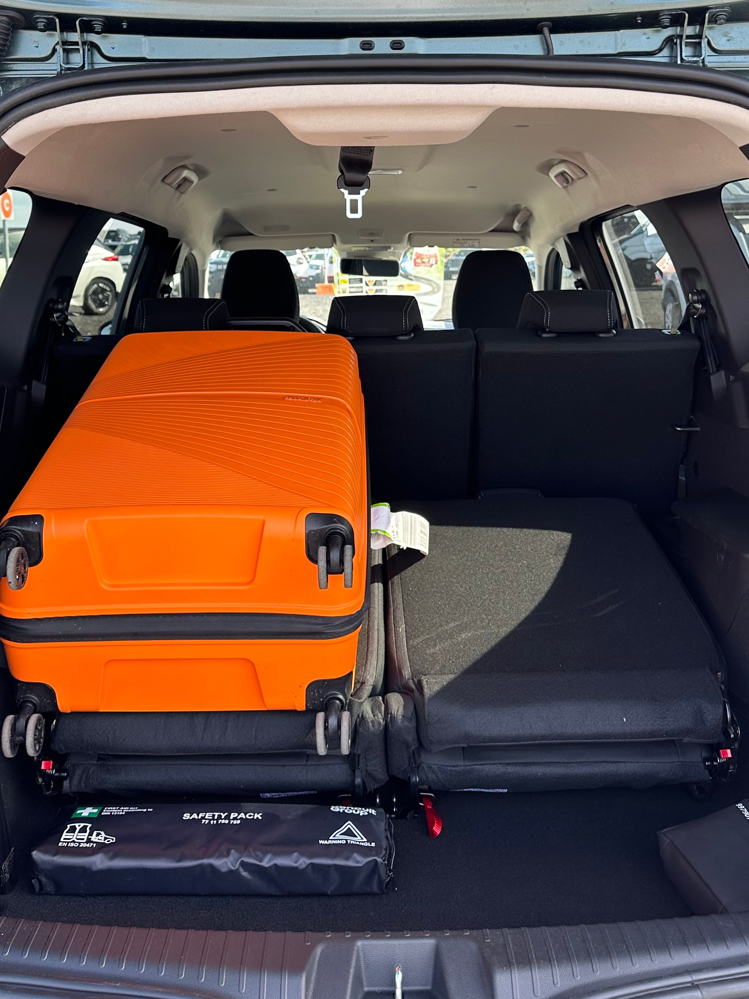 Kofferraumvolumen des Jogger Kofferraum des Dacia Jogger mit orangefarbenem Koffer zur Veranschaulichung des verfügbaren Gepäckraums