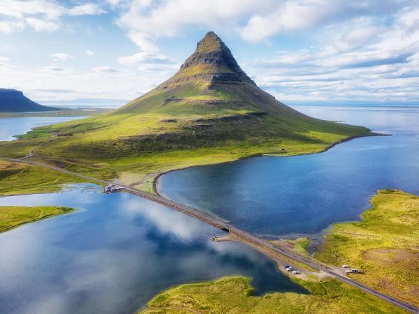 road leading to a mountain sitting in a large body of water