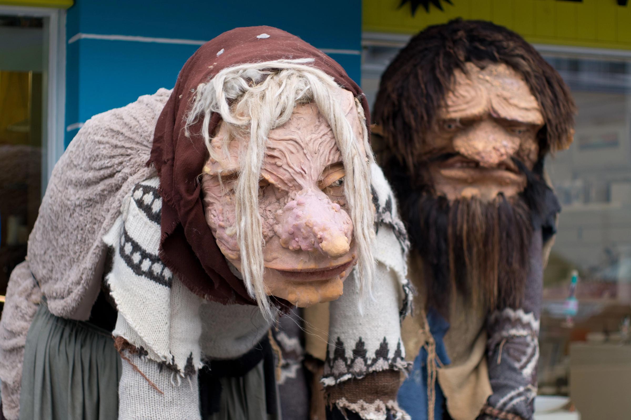 a man and a woman wearing masks are standing next to each other .