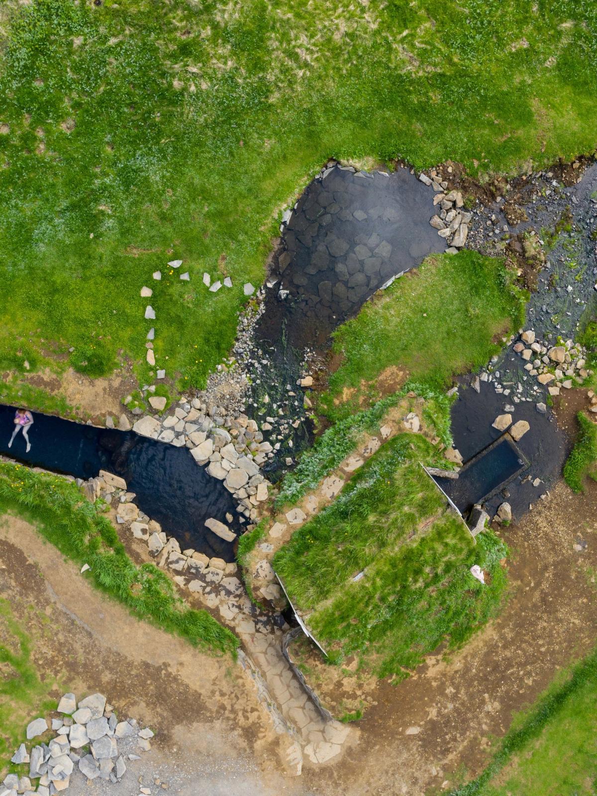 una vista aérea de un río rodeado de césped y rocas.