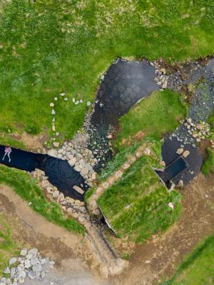 una vista aérea de un río rodeado de césped y rocas.
