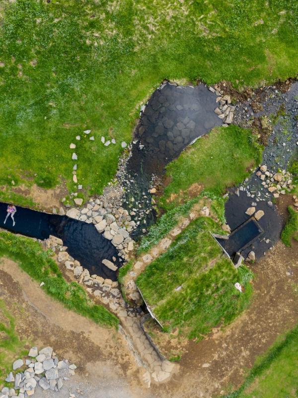 una vista aérea de un río rodeado de césped y rocas.