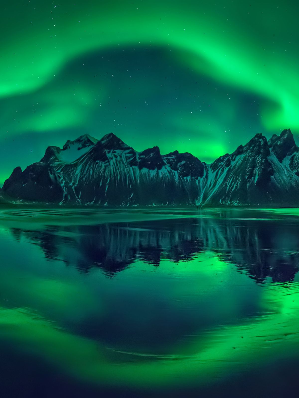 Vestrahorn por la noche durante la aurora boreal