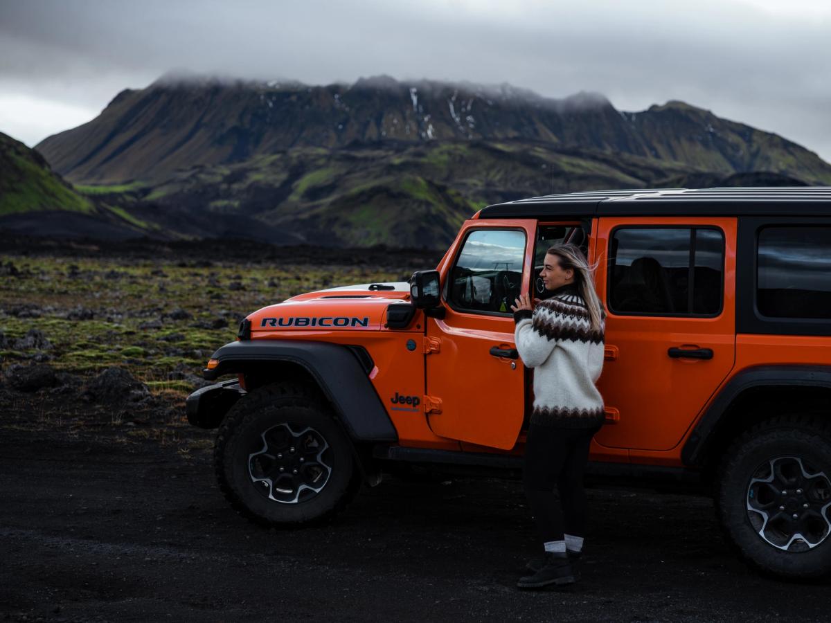 牧马人 Rubicon 侧面图 Jeep Wrangler Rubicon 4x4 侧视图,车门打开,旁边站着一人