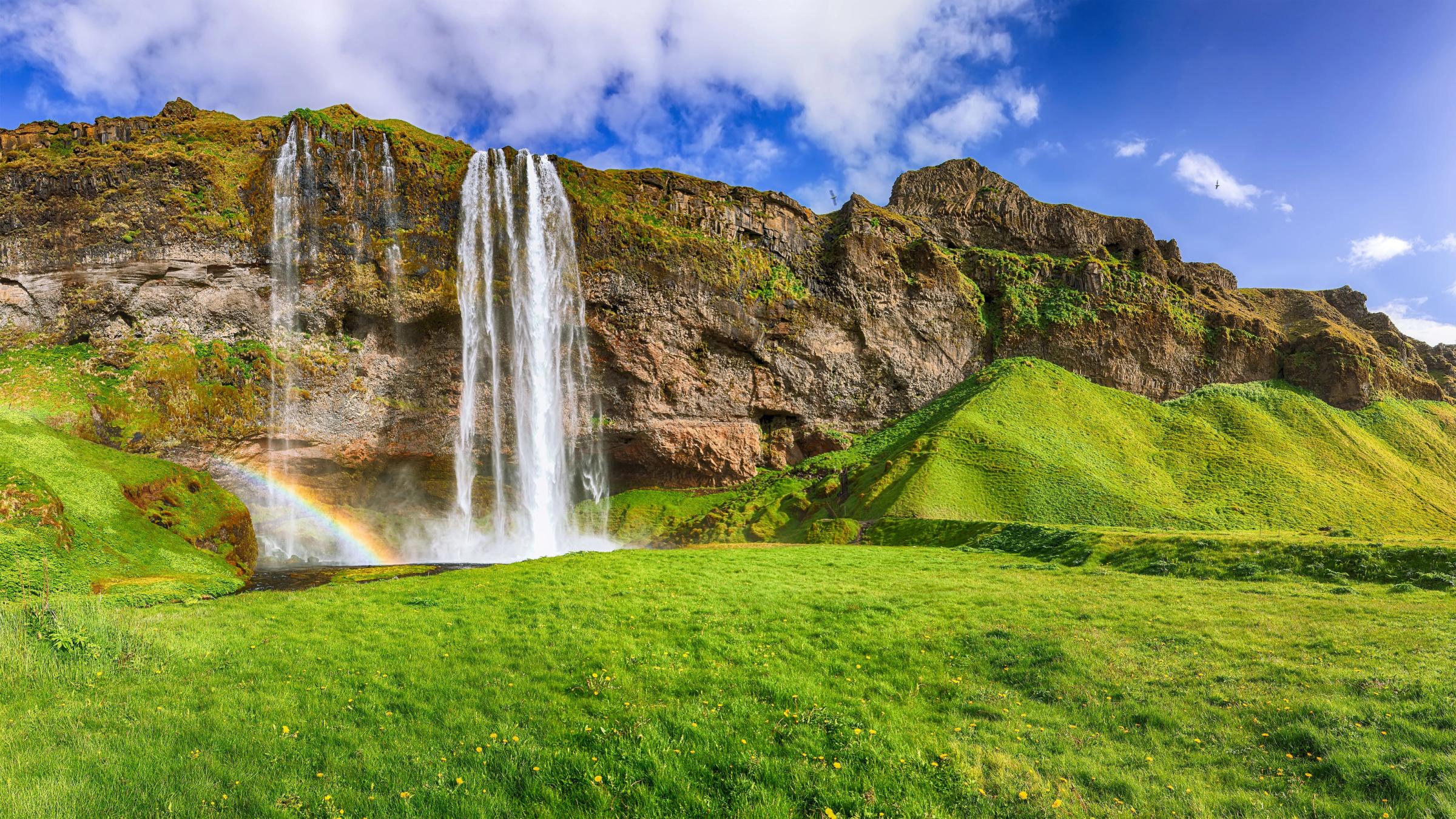 una cascada con un arcoíris en medio de ella