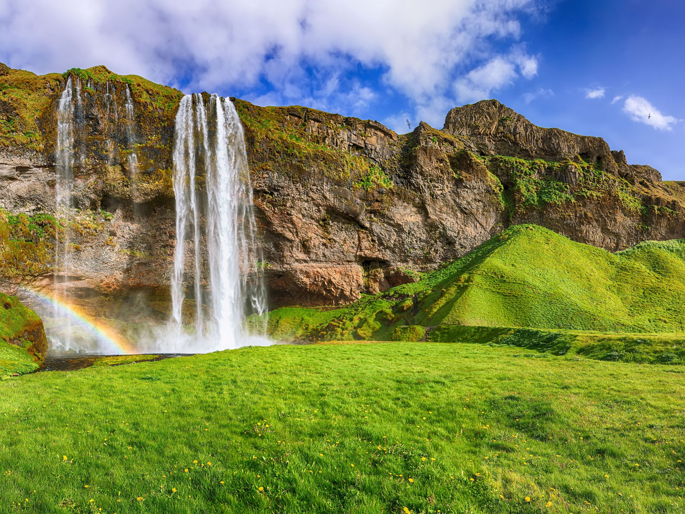 una cascada con un arcoíris en medio de ella