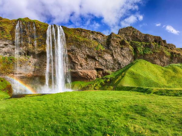 una cascada con un arcoíris en medio de ella