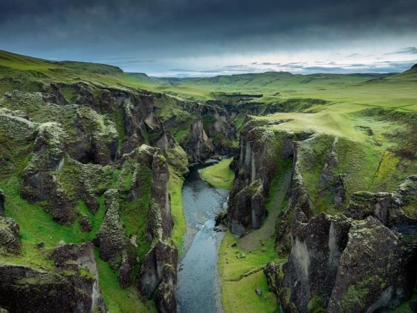 an aerial view of a river running through a canyon surrounded by mountains .