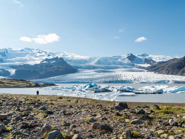 two people admiring a glacier and a lagoon