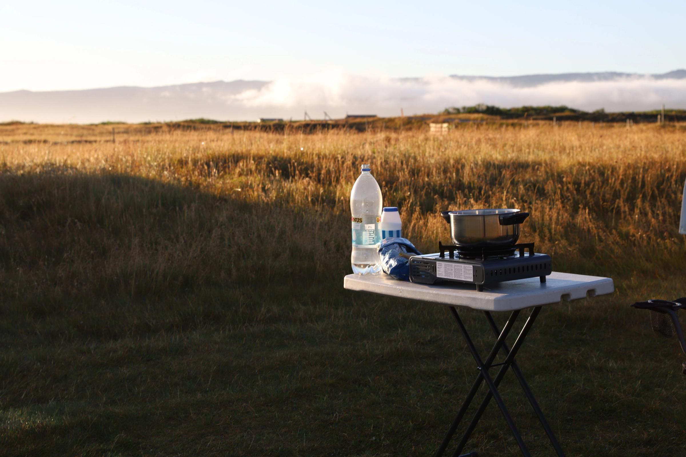 Cooking gear, a plastic waterbottle, salt and past on a table