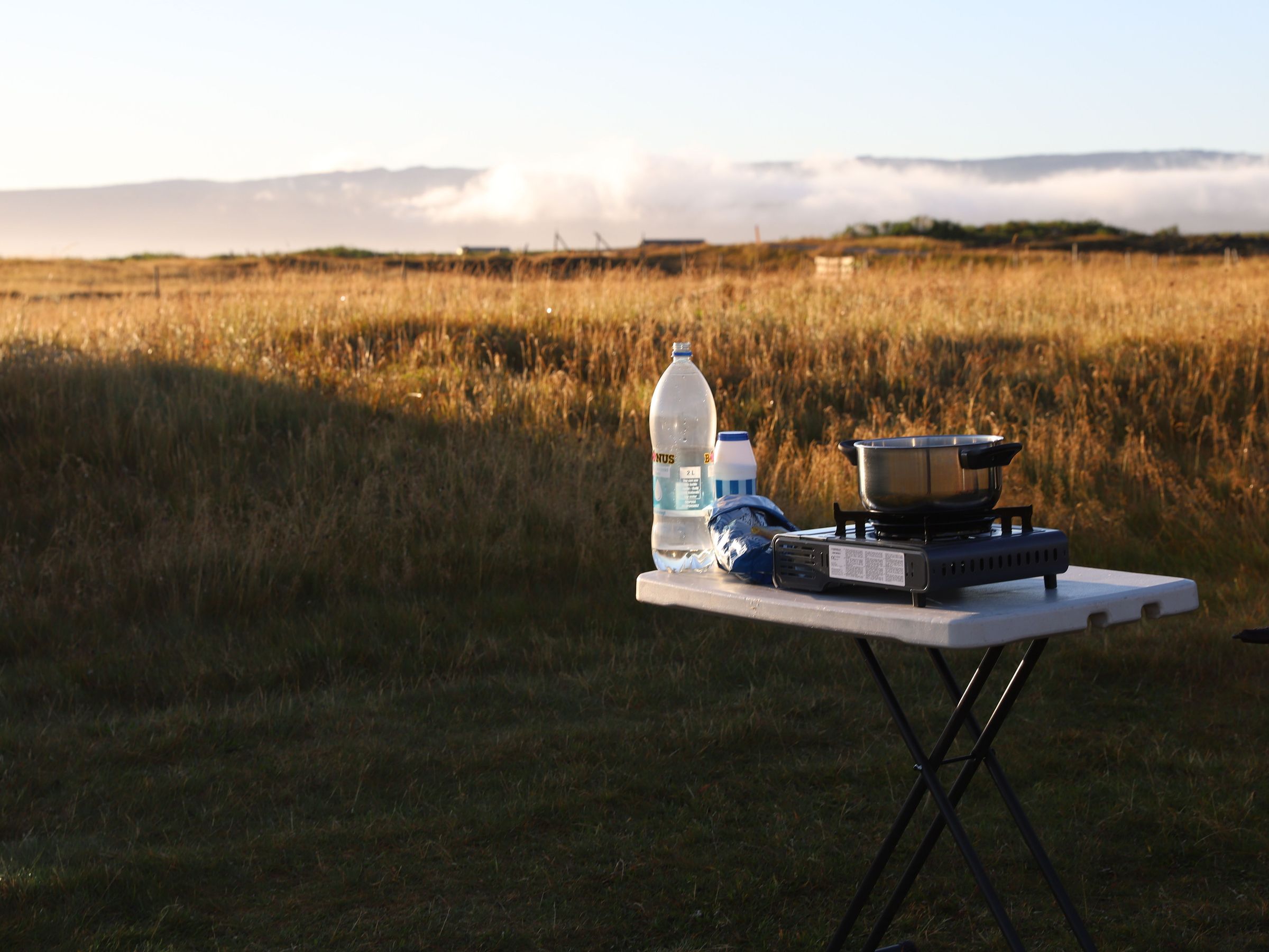 Cooking gear, a plastic waterbottle, salt and past on a table