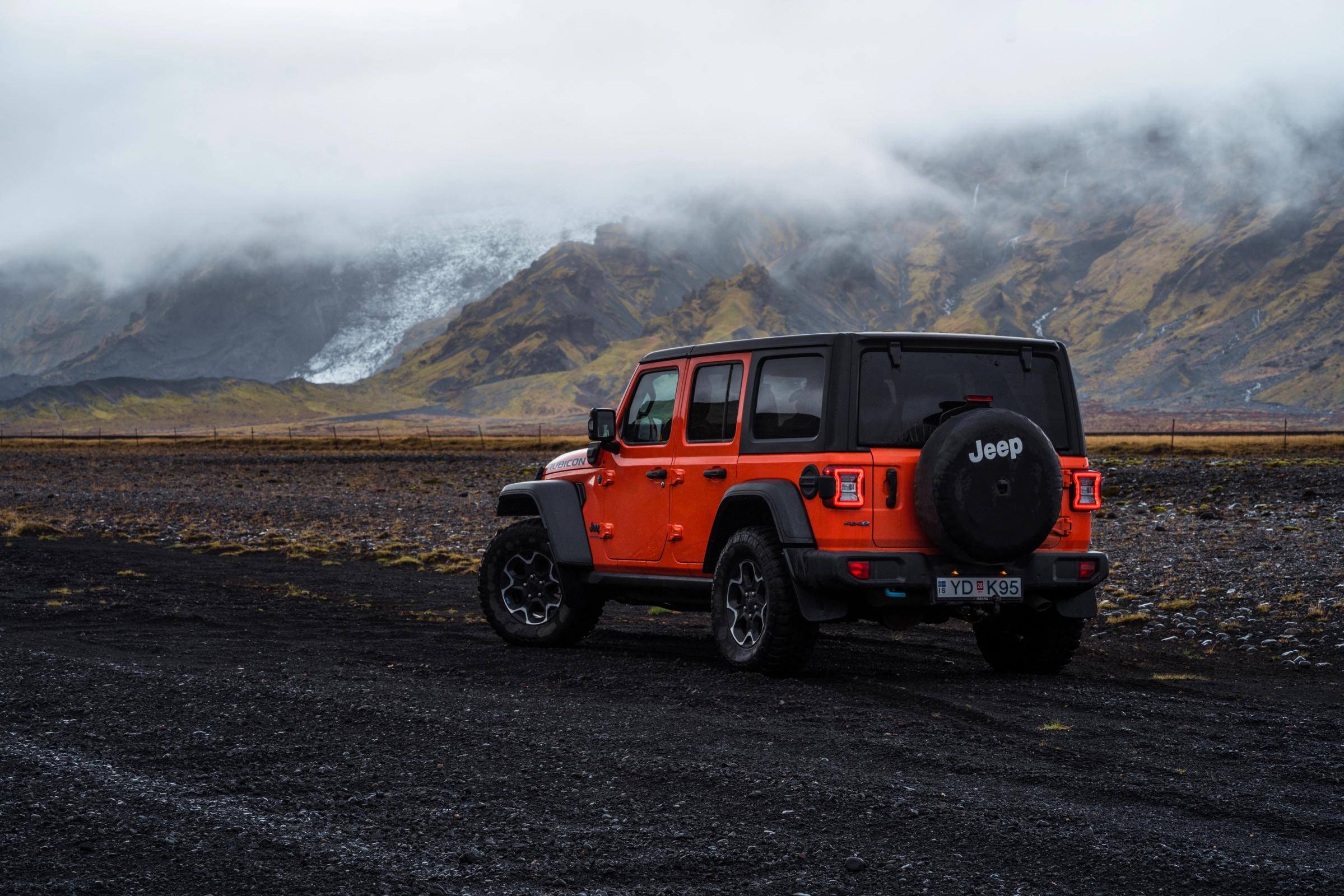 停放着的 Jeep Wrangler Rubicon 4x4 后视图，群山上空低云笼罩