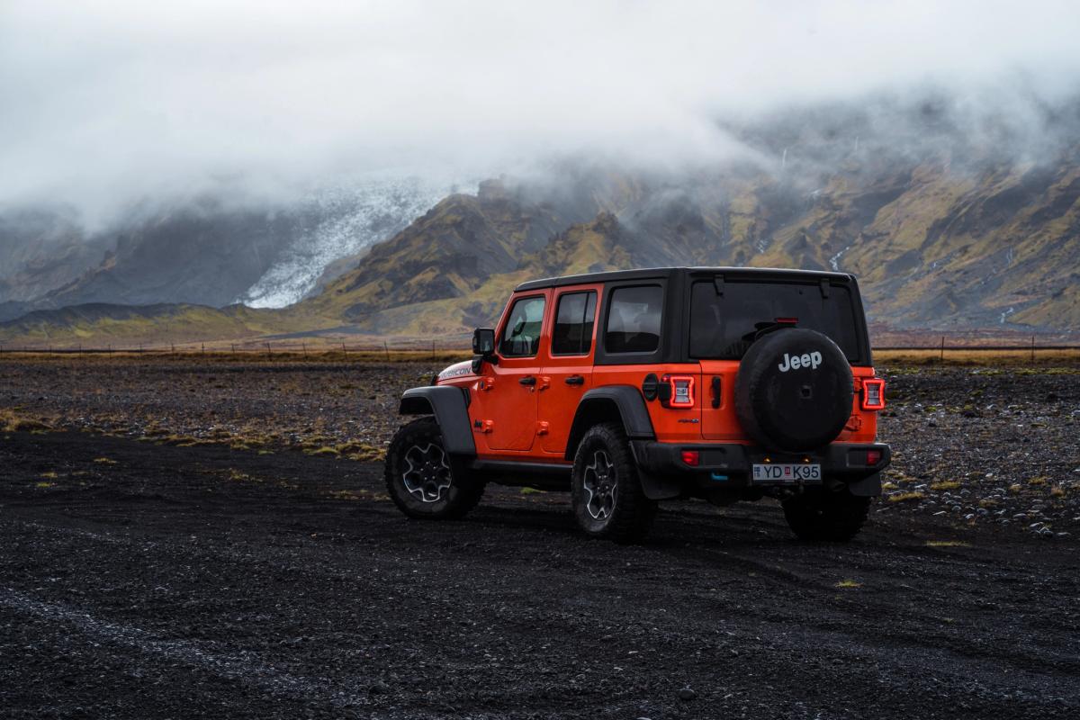 停放着的 Jeep Wrangler Rubicon 4x4 后视图，群山上空低云笼罩