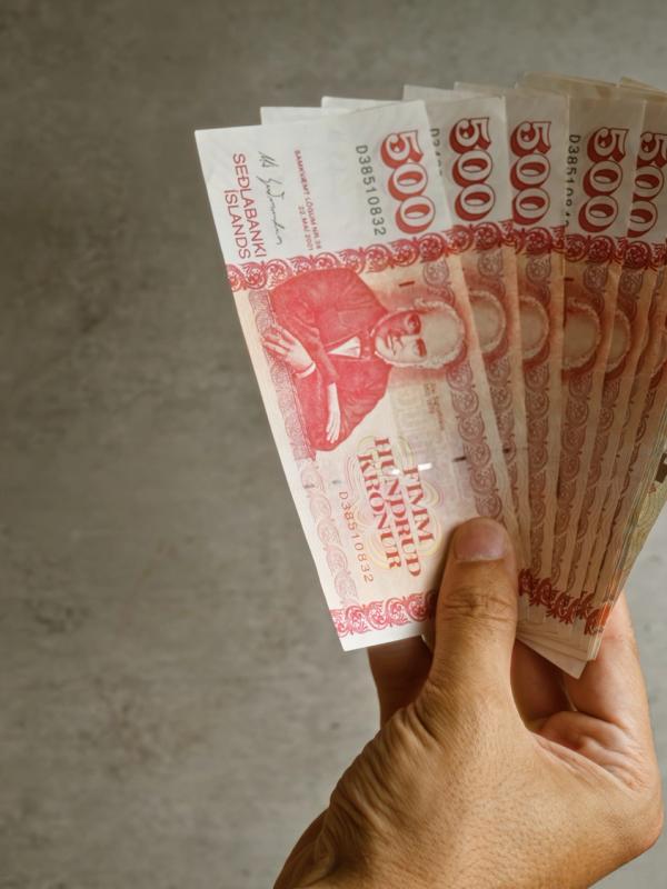 a person is holding a fan of money in their hand