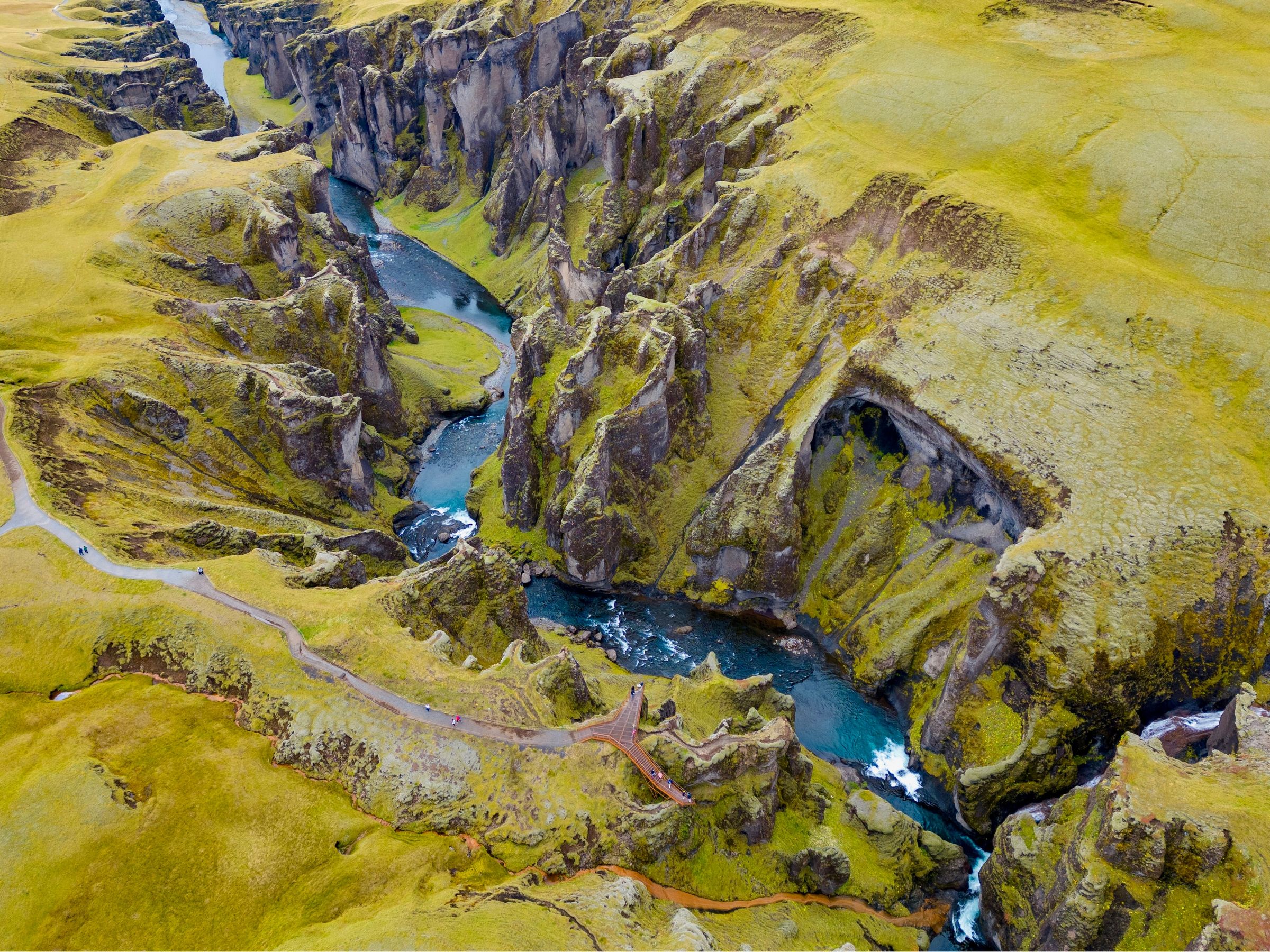 an aerial view of a river flowing through a canyon surrounded by mountains .