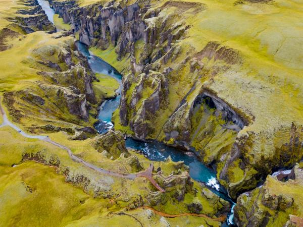 an aerial view of a river flowing through a canyon surrounded by mountains .