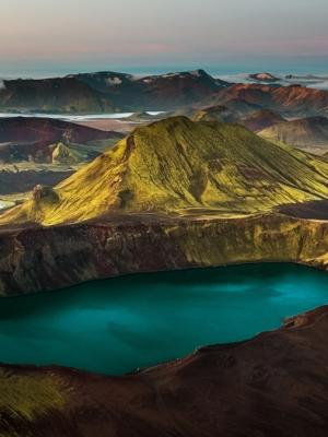 an aerial view of a lake in the middle of a mountain surrounded by mountains .
