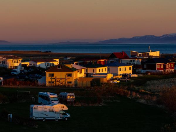 Campsite with campervans and motorhomes in the middle of a tiny village