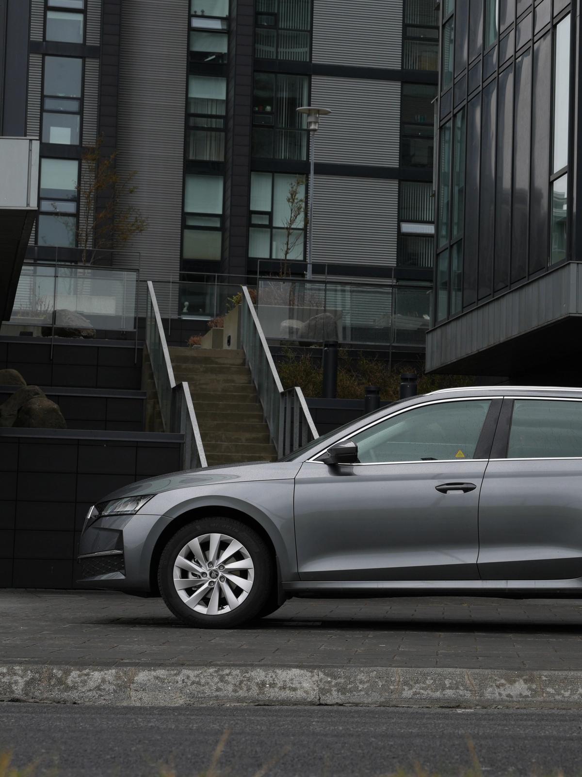 a skoda octavia station wagon is parked in front of a building .