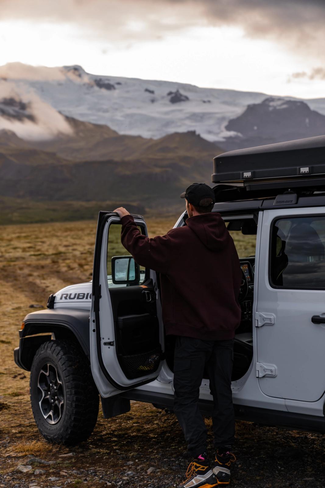 a man getting out of a white jeep with the word rubicon on the front