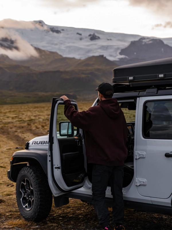a man getting out of a white jeep with the word rubicon on the front