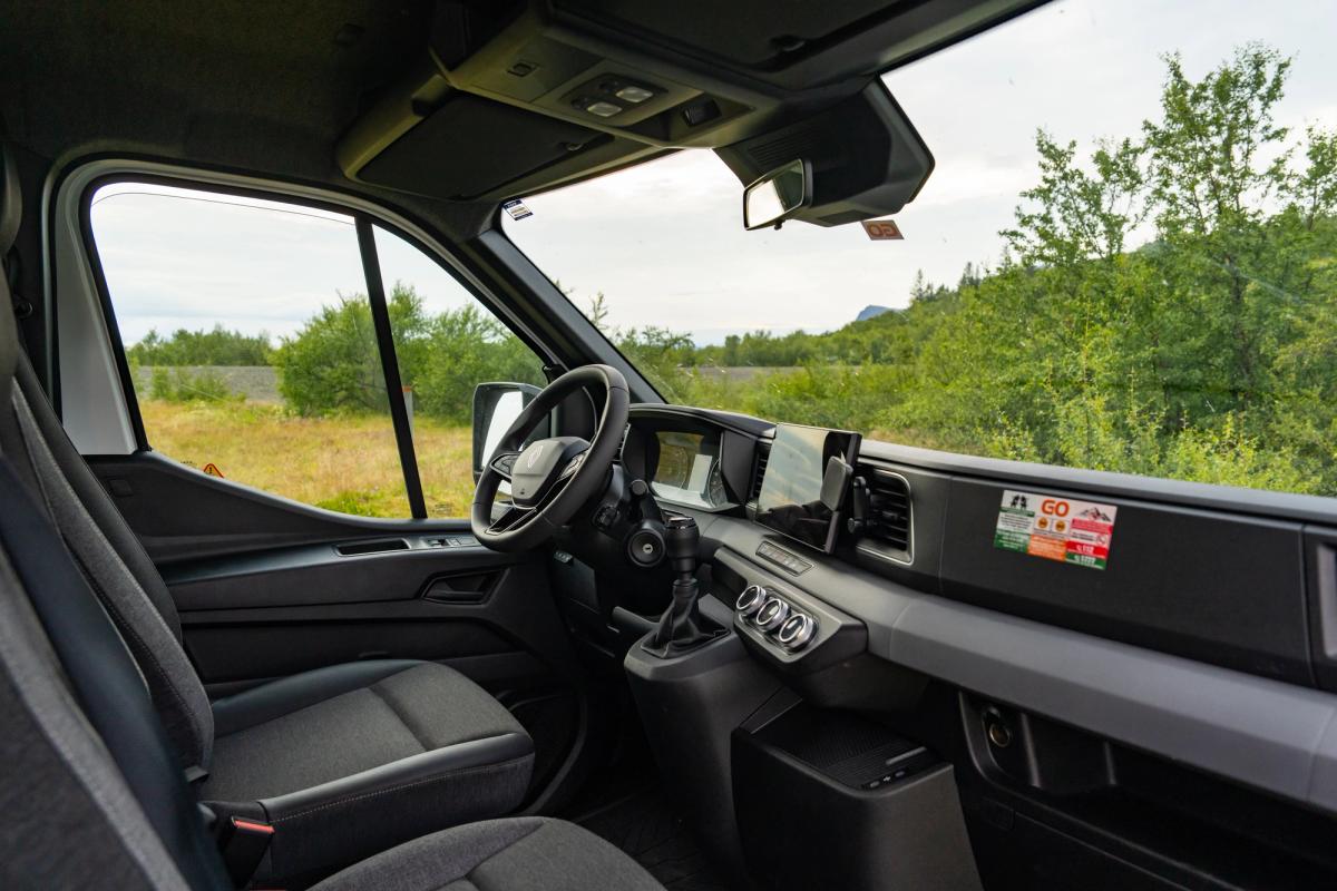 Steering wheel, gear stick and phone holder in the cab of a large camper