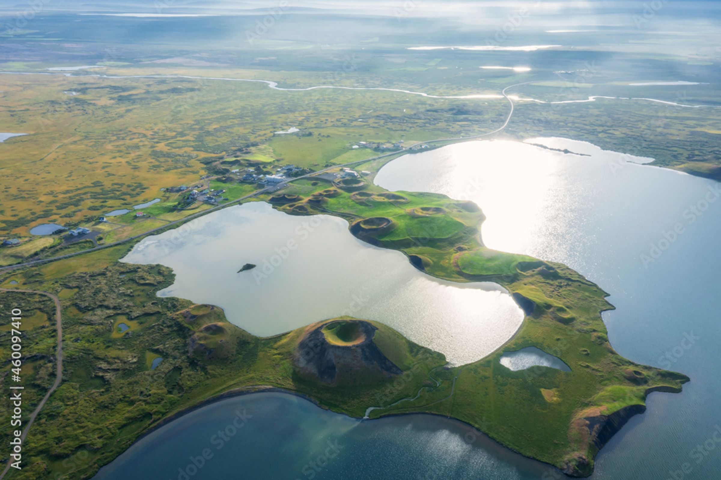 Aerial view of shimmering lakes, green landscapes, and numerous volcanic craters.