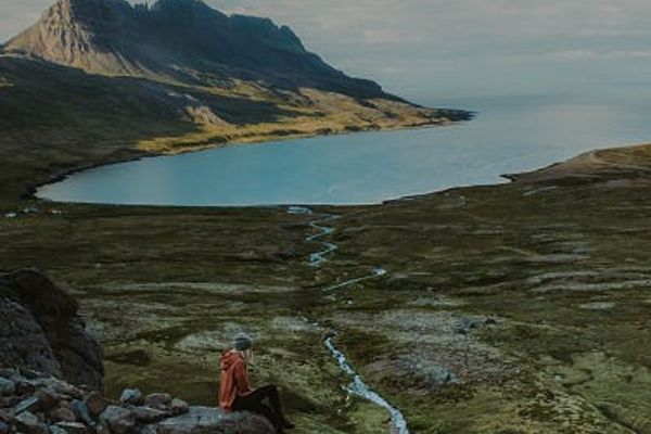 Persona sentada en un roca mirando al horizonte