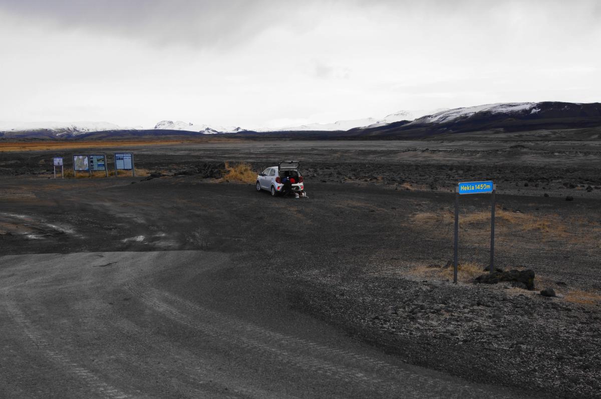a white truck is parked in the middle of a dirt road .