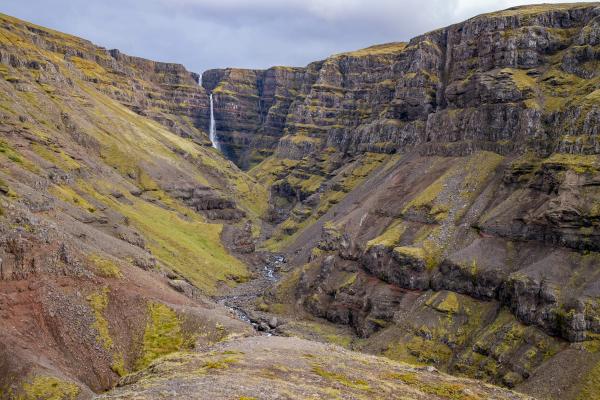 there is a waterfall in the middle of a canyon at strútsfoss in iceland.