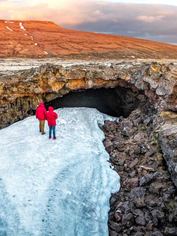 Un couple sur une grotte enneigée à Surtshellir dans le Silver Circle d'Islande