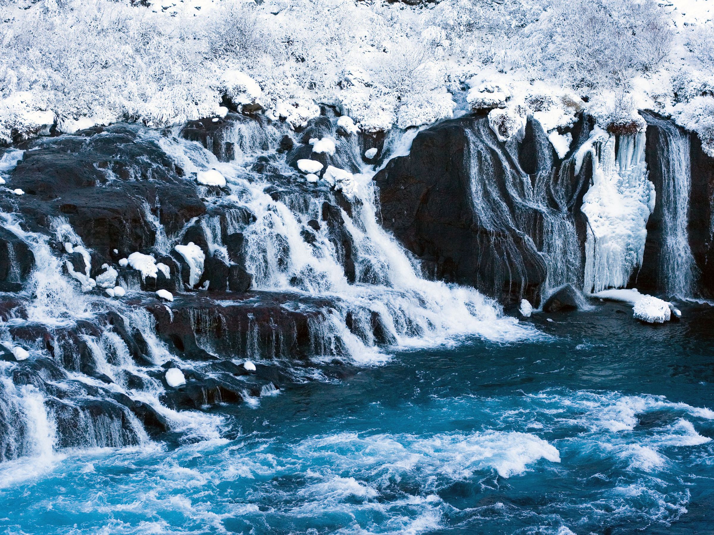 Hraunfossar Waterfall covered in snow during winter
