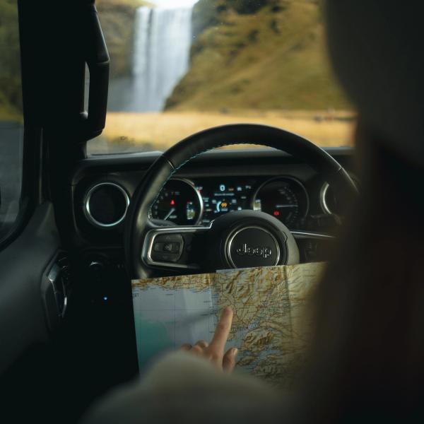 Una mujer sentada en la puerta de una furgoneta blanca.