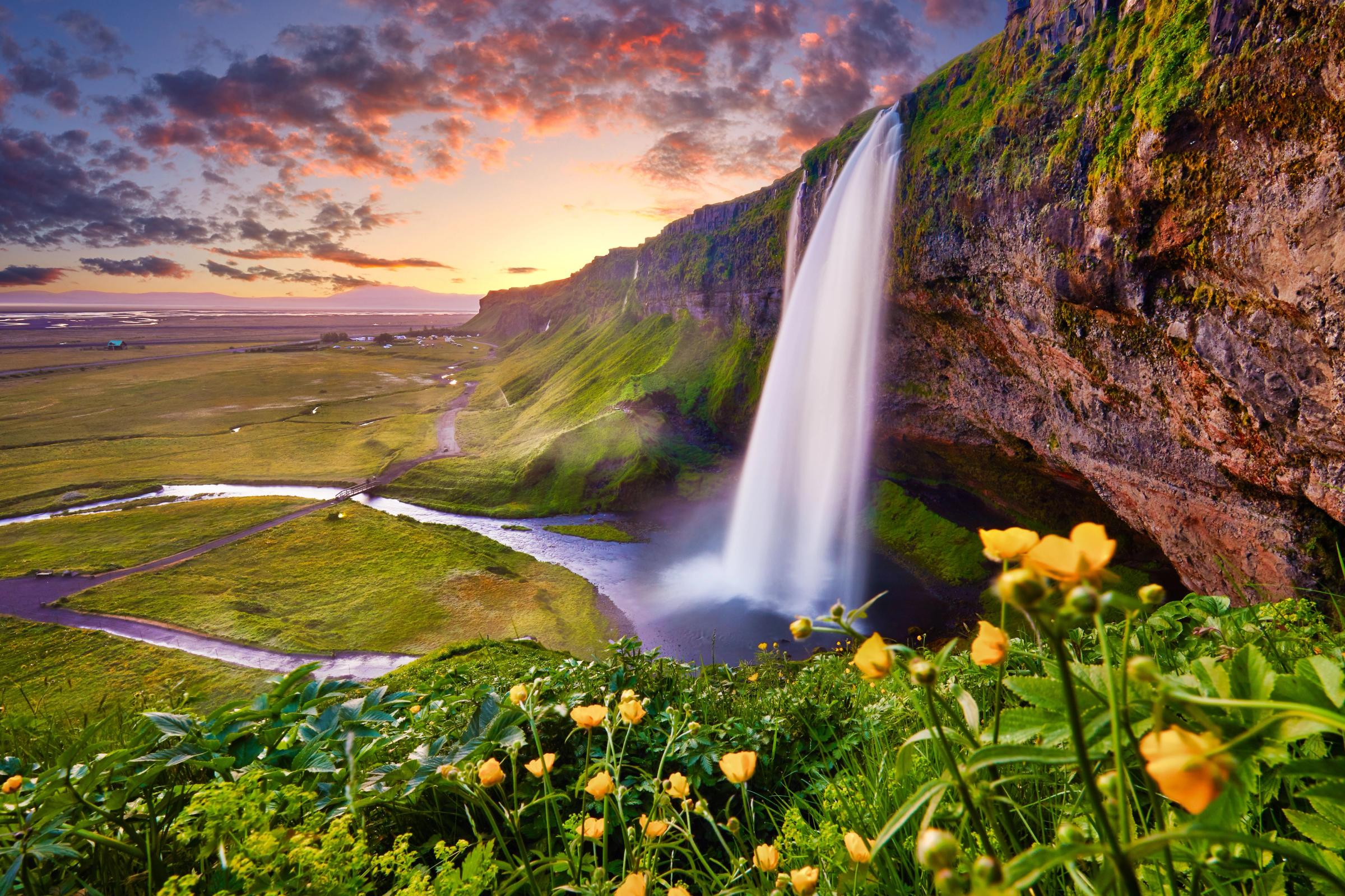 Seljalandsfoss vista de cerca con el sol poniéndose en el horizonte