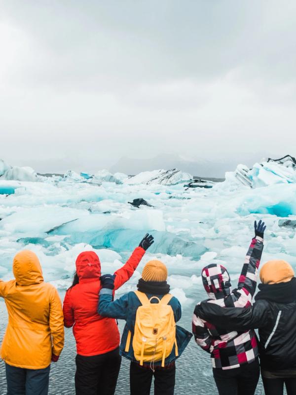 5 amigos divirtiéndose de pie cerca del agua en Islandia