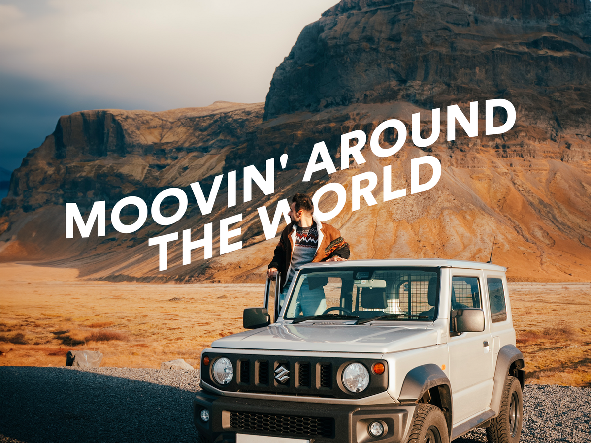 a man sits on the roof of a suzuki jeep