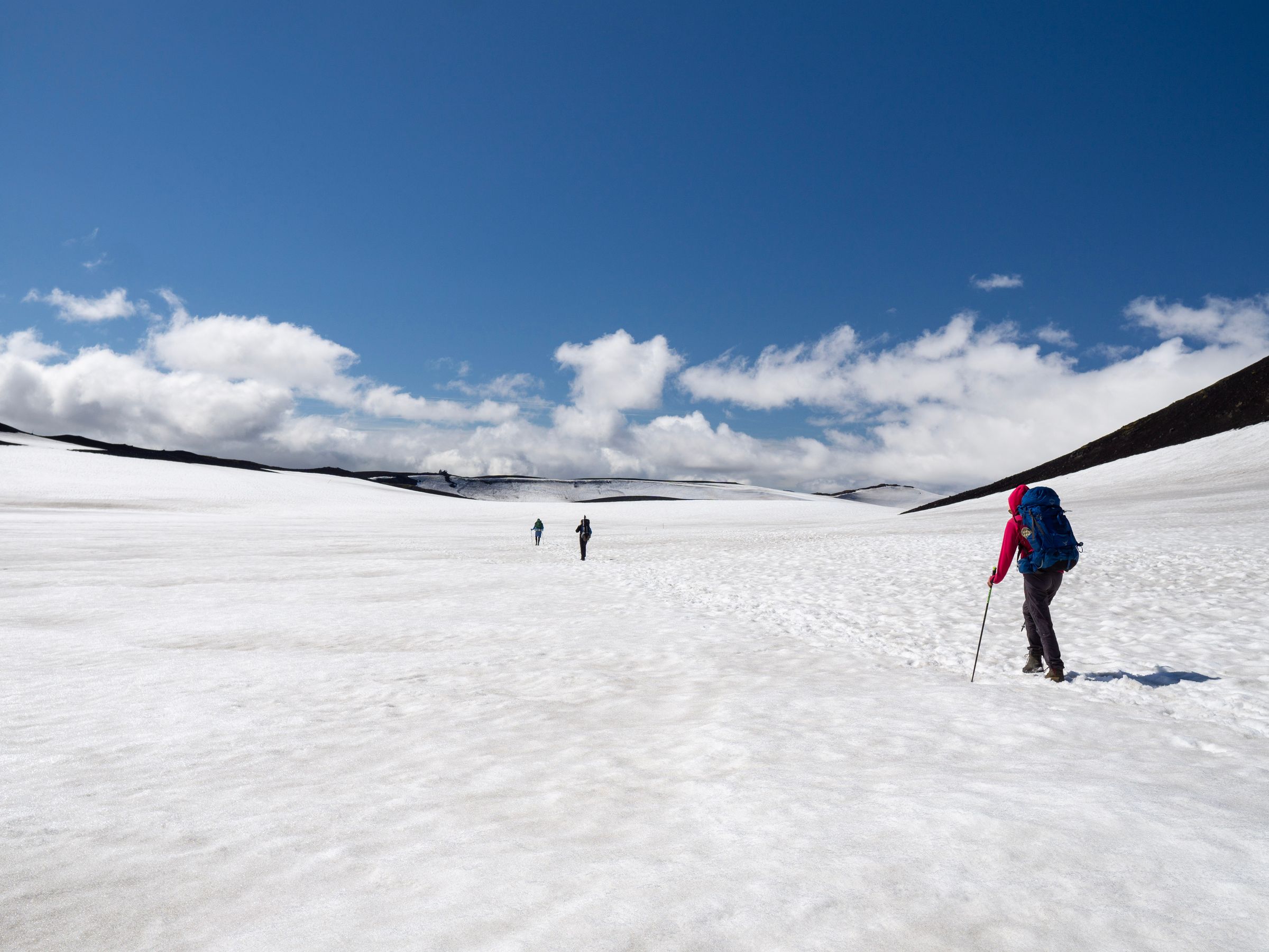 a group of people are walking through a snowy field, Fimmvörðuháls hike