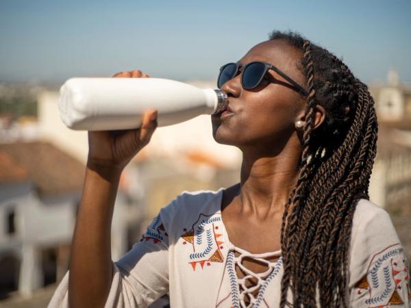woman drinking from a reusable water bottle