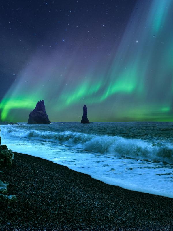 the aurora borealis is shining over the ocean in iceland.